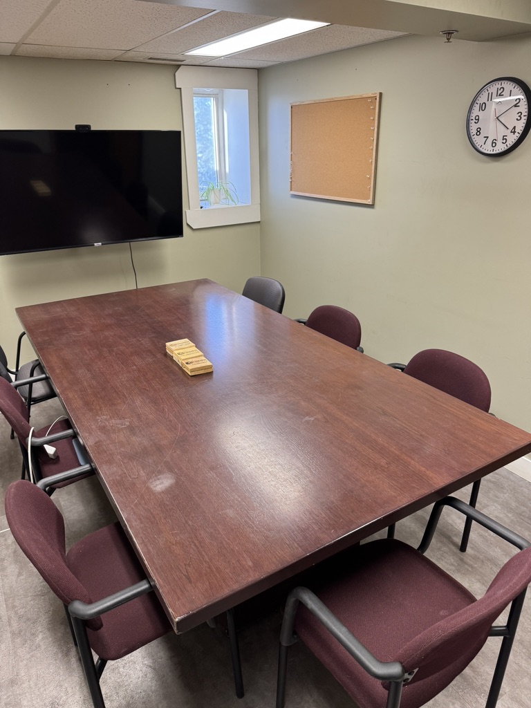Boardroom at Charlesworth Ave Cochrane with large conference table, TV screen and cork board seating 8