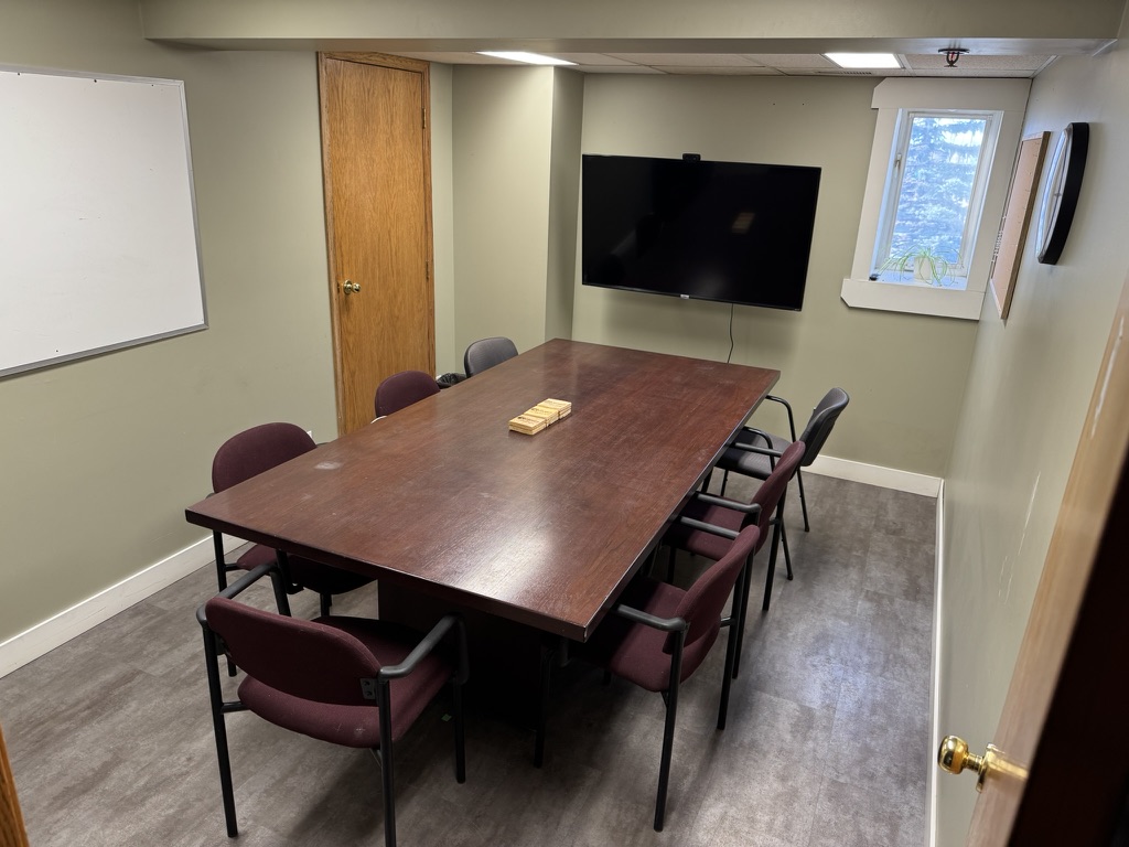 Full view of boardroom at 250 Charlesworth Ave Cochrane with TV, whiteboard and conference seating for 8