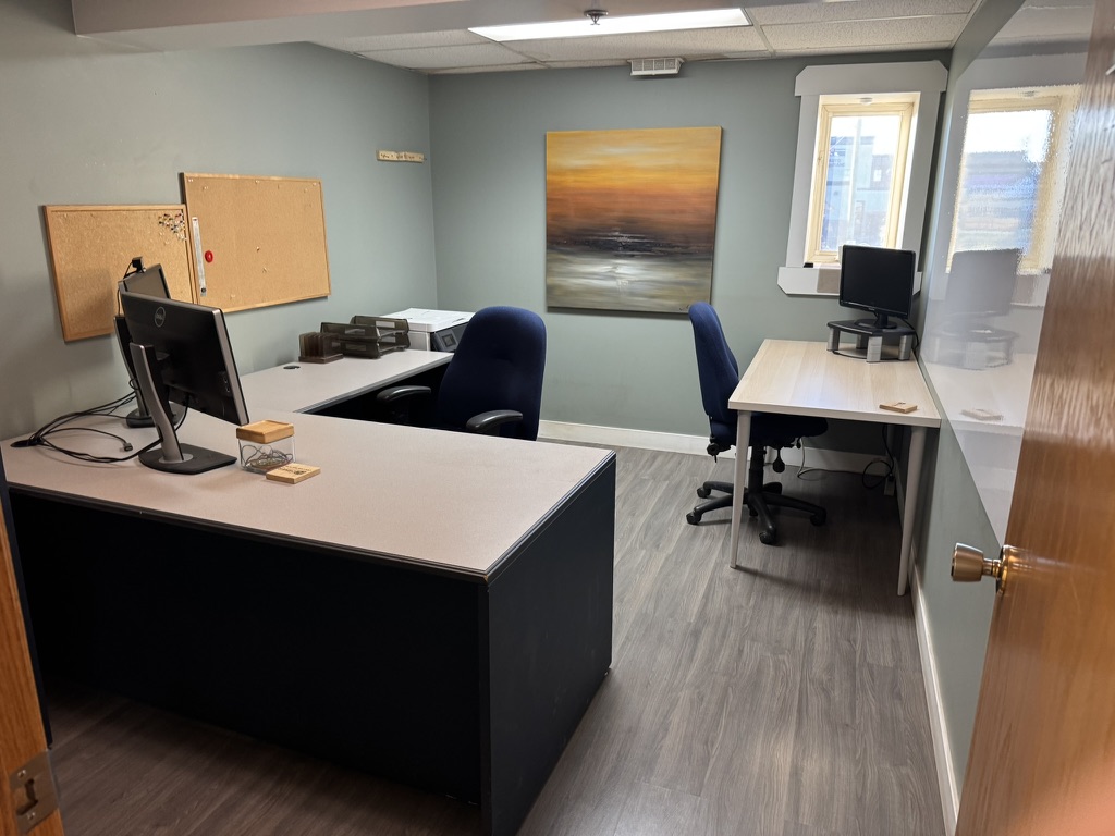 Team office at 250 Charlesworth Ave Cochrane with two desk workstations and wall artwork