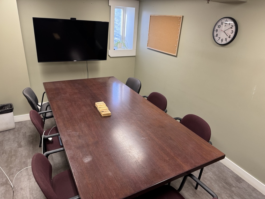 Boardroom conference table at The Corner Coworking Charlesworth with seating for 8 and wall-mounted TV