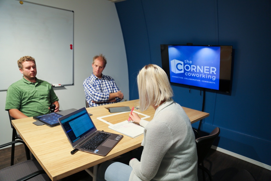 Three-person meeting in The Corner Coworking boardroom
